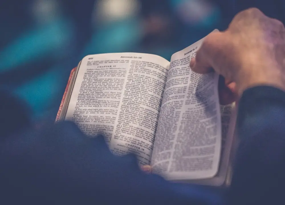 Manos sosteniendo una Biblia abierta